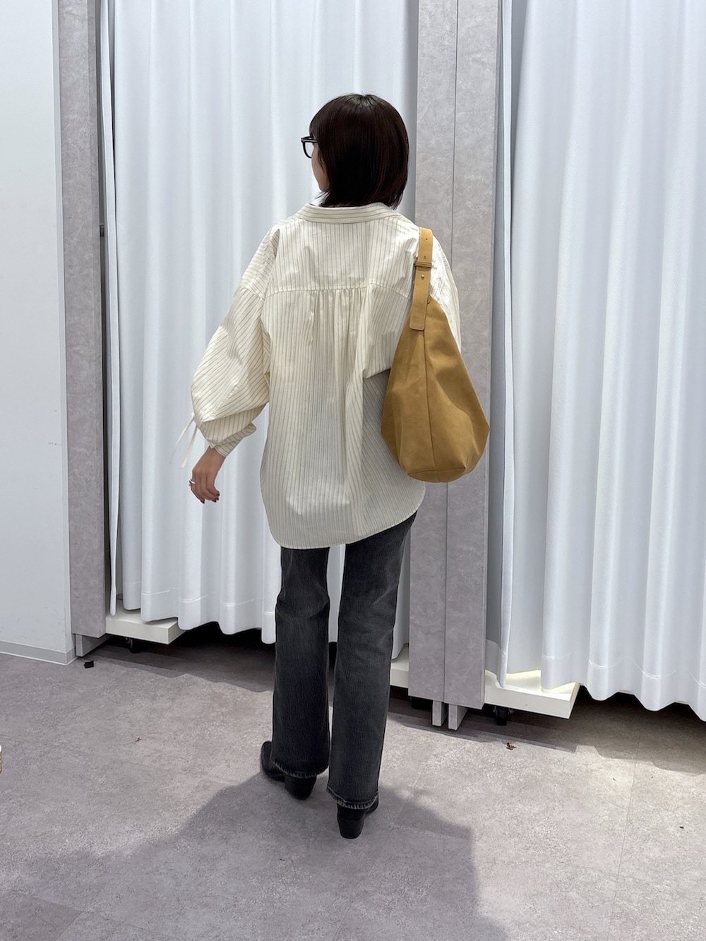 ホワイト系のシャツ/ブラウス、ブルー系のデニムパンツを着用したレディースの秋コーディネートの3枚目の写真