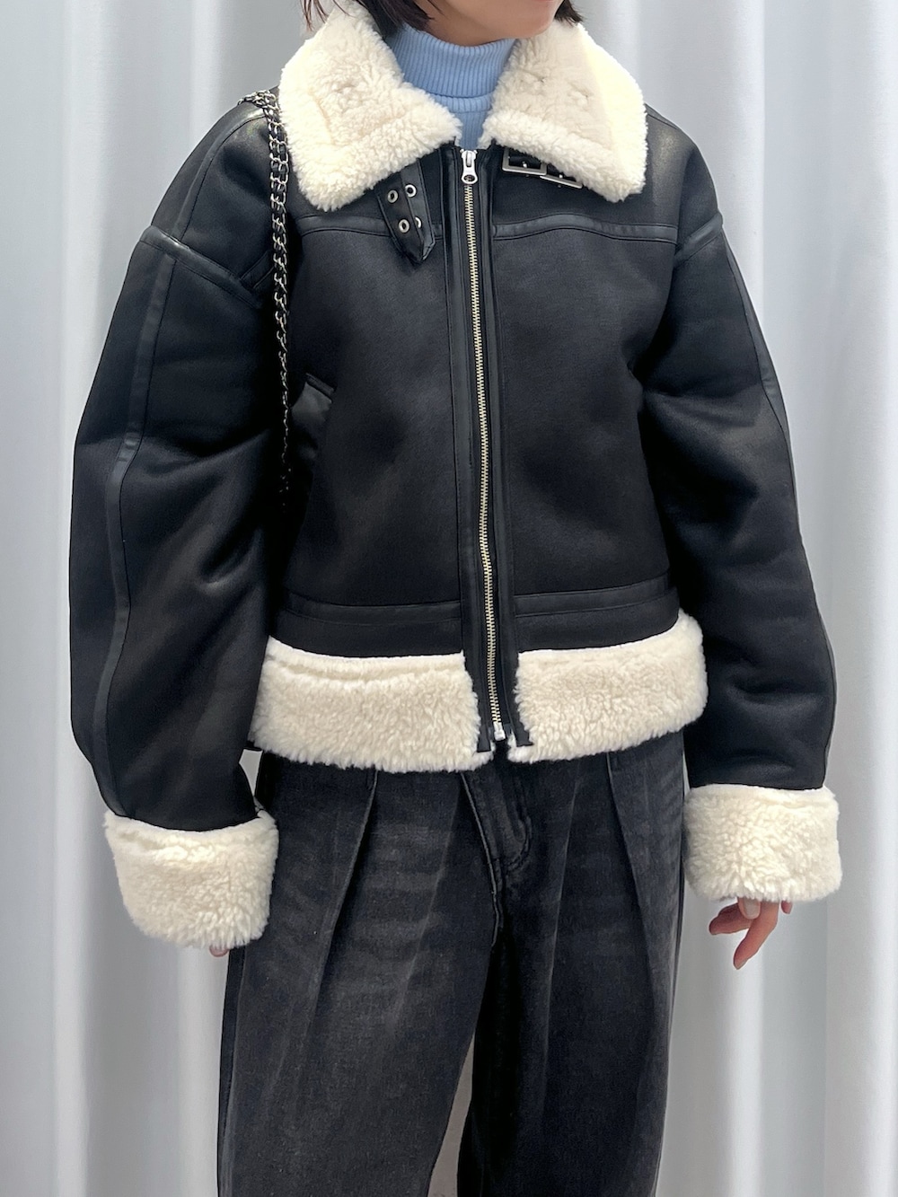 ブラック系のその他アウター、ブルー系のデニムパンツ、オレンジ系のニット/セーターを着用したレディースの冬コーディネートの4枚目の写真