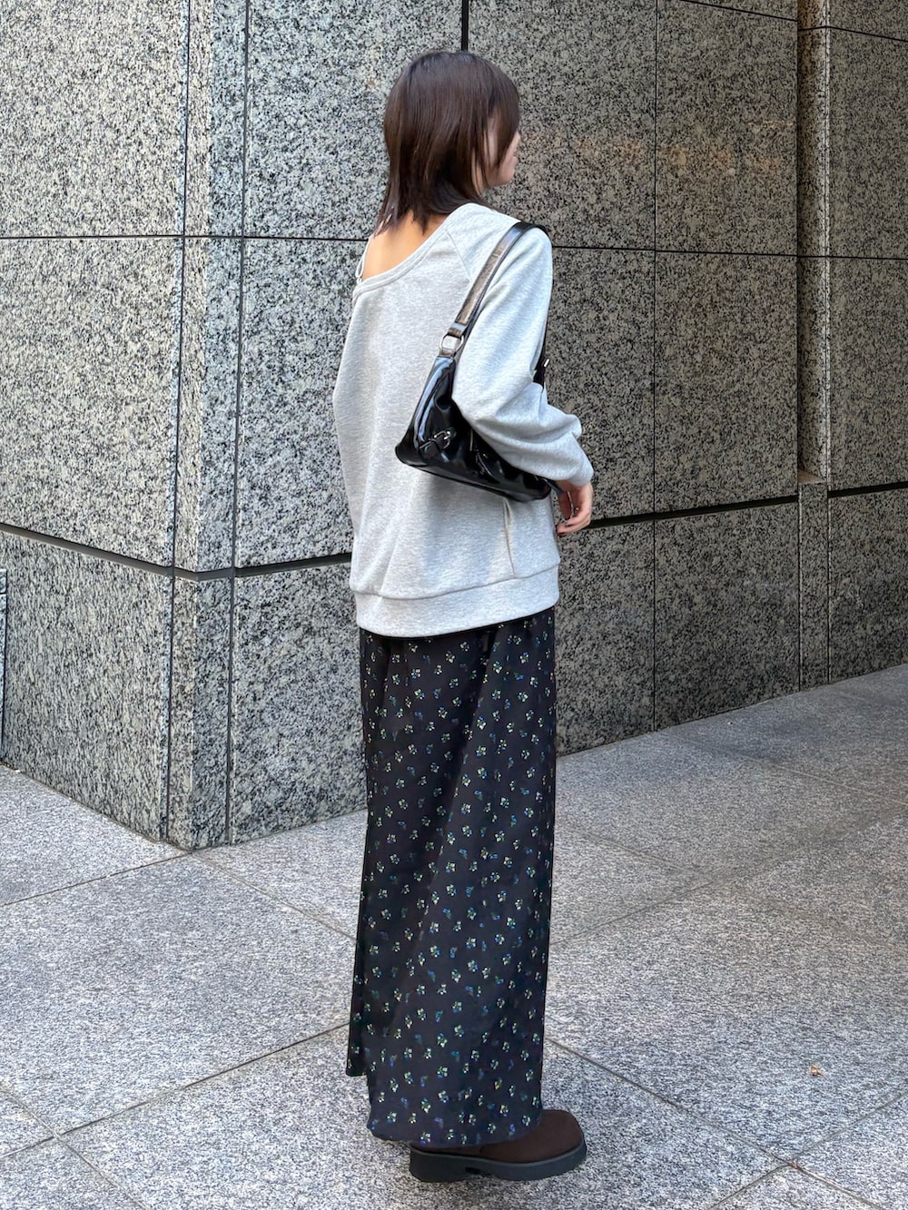 グレー系のスウェット、ブラック系のワンピースを着用したレディースの冬コーディネートの2枚目の写真