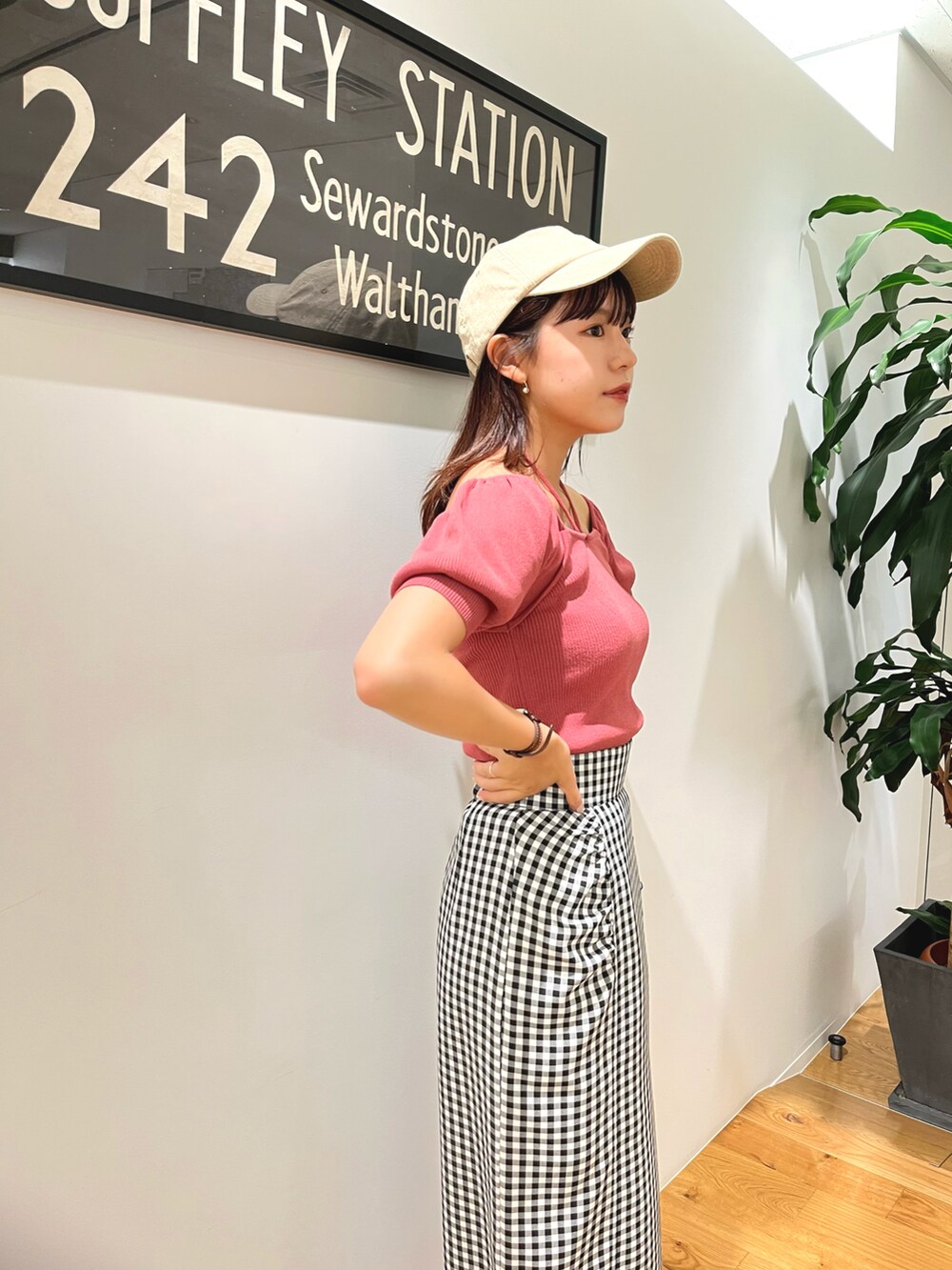 ピンク系のニット/セーター、ホワイト系のスカート、ベージュ系のキャップを着用したレディースの夏コーディネートの2枚目の写真