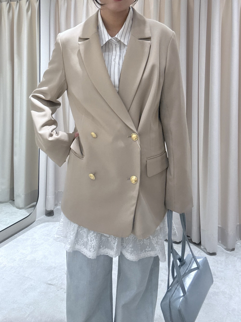 ホワイト系のシャツ/ブラウス、ブルー系のデニムパンツを着用したレディースの春コーディネートの3枚目の写真