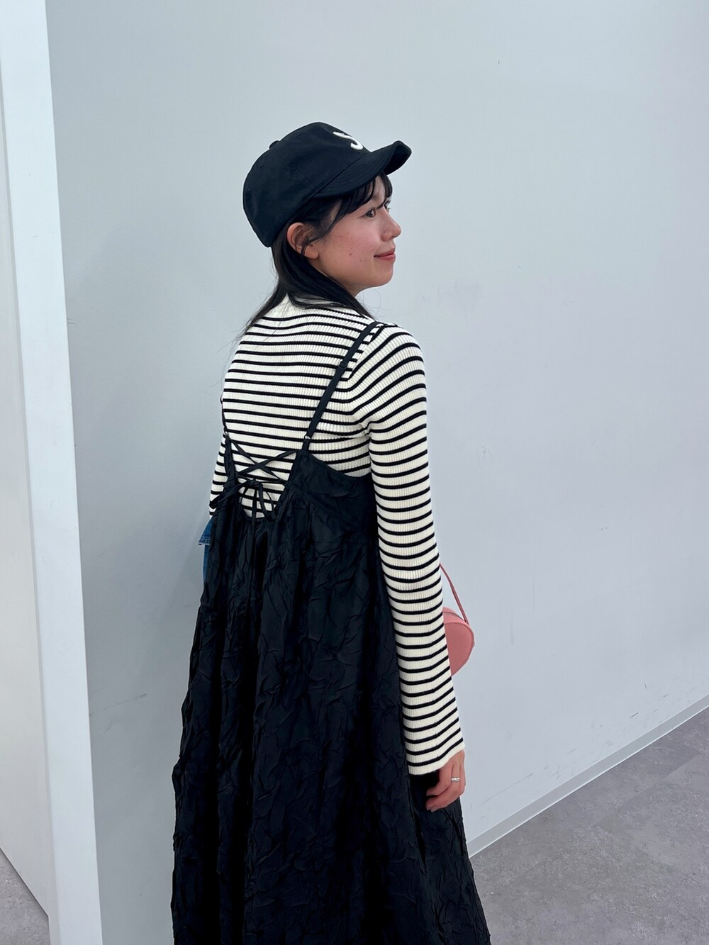 ブルー系のデニムジャケット、ブラック系のワンピース、シルバー系のショルダーバッグを着用したレディースの冬コーディネートの3枚目の写真