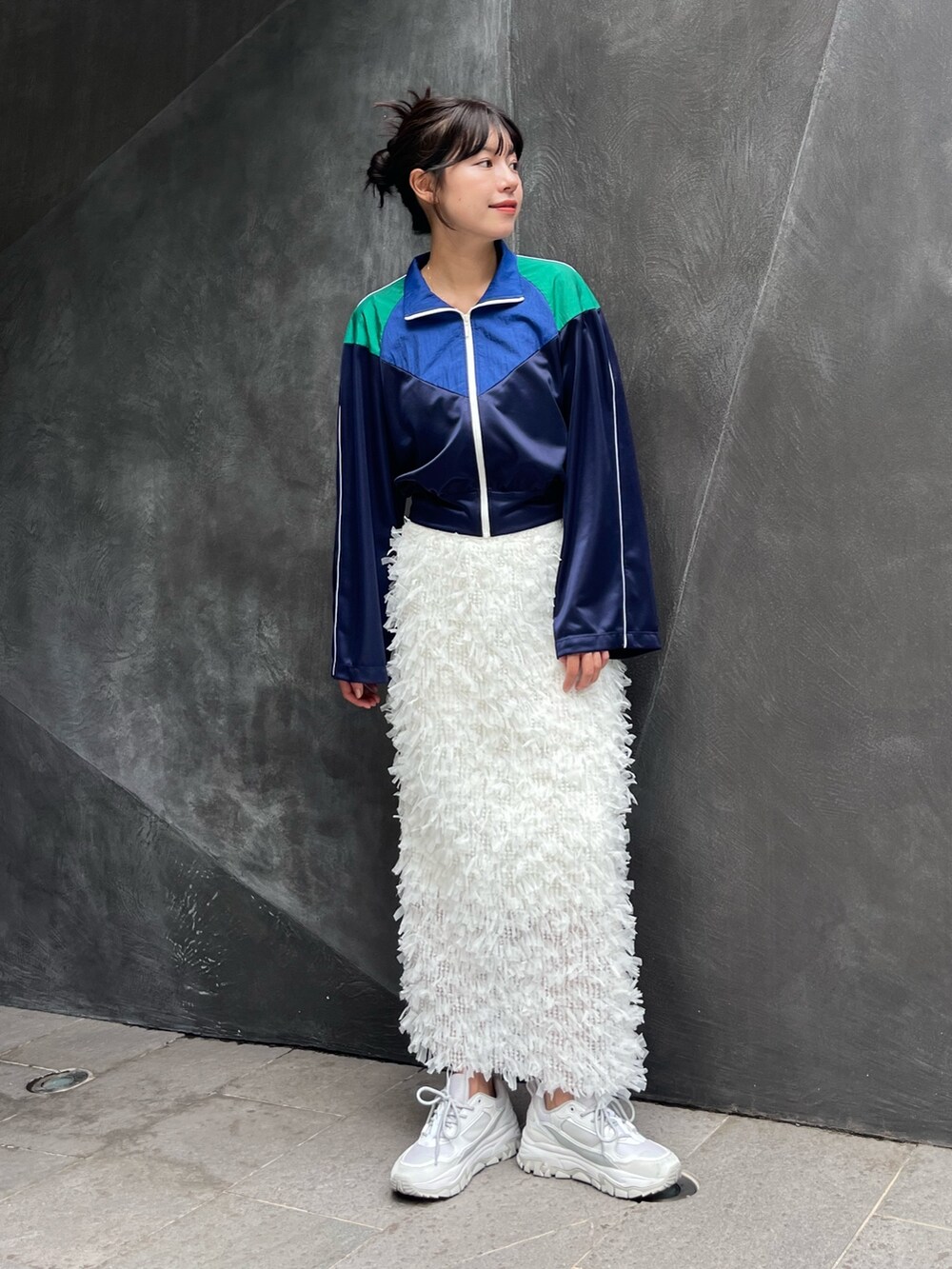 ブルー系のナイロンジャケット、ホワイト系のスカートを着用したレディースの秋コーディネートの2枚目の写真