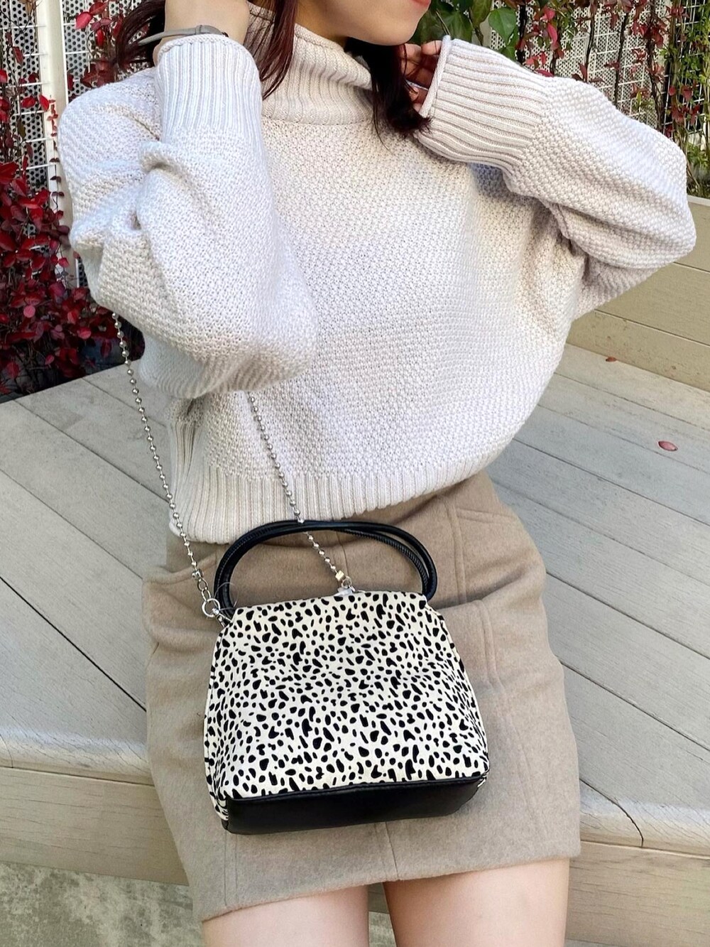 ホワイト系のニット/セーター、ブラウン系のスカート、ホワイト系のハンドバッグを着用したレディースの秋コーディネートの3枚目の写真