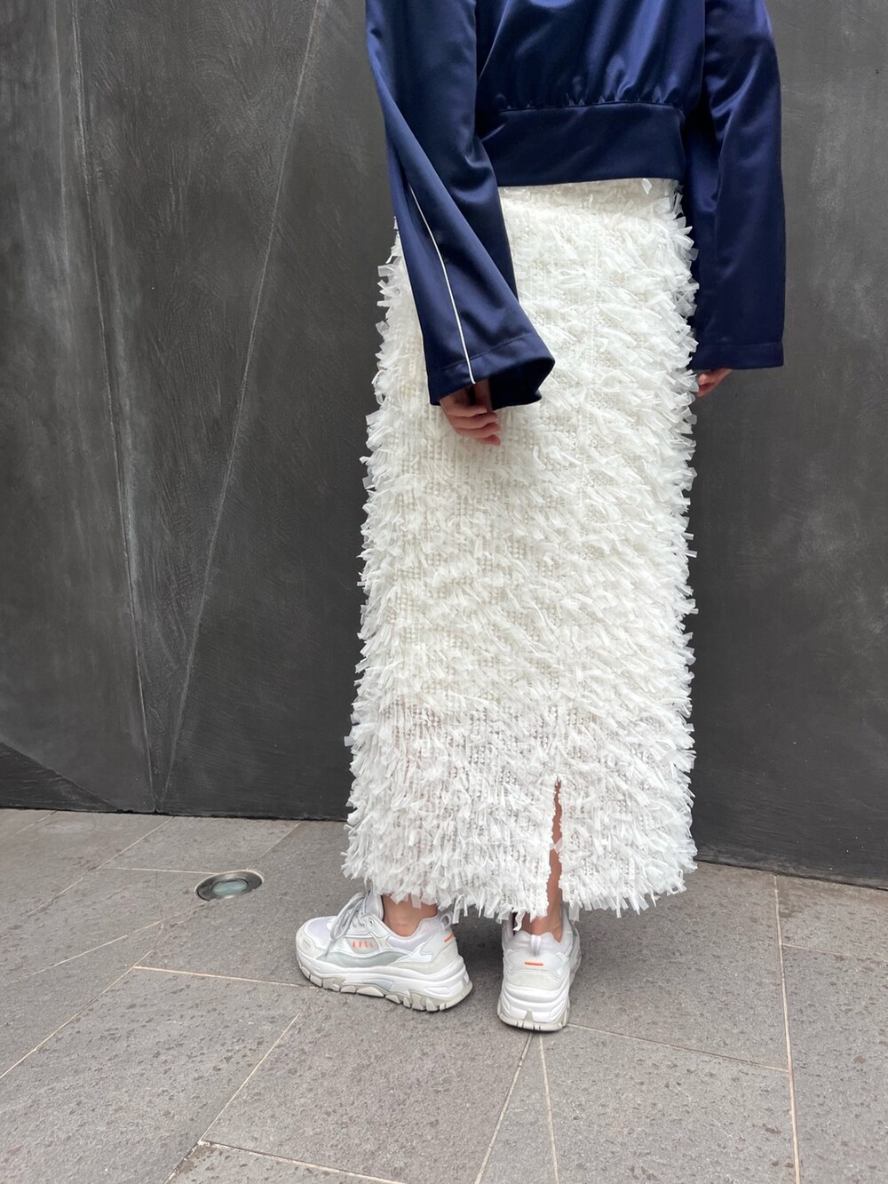 ブルー系のナイロンジャケット、ホワイト系のスカートを着用したレディースの秋コーディネートの4枚目の写真