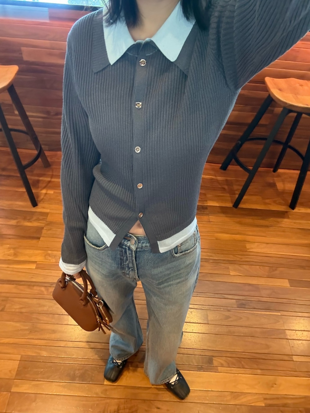 グレー系のニット/セーター、ブルー系のデニムパンツを着用したレディースの冬コーディネートの2枚目の写真