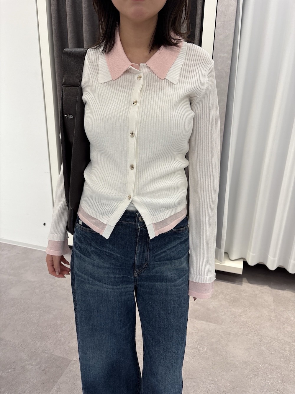 グレー系のニット/セーター、ブルー系のデニムパンツを着用したレディースの冬コーディネートの3枚目の写真