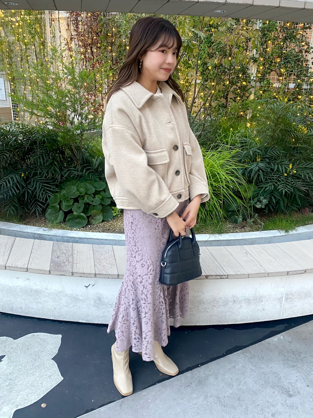 ブラウン系のブルゾン、ブラック系のショルダーバッグ、パープル系のスカートを着用したレディースの冬コーディネートの3枚目の写真