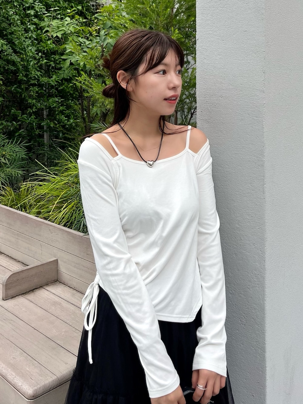 ホワイト系のTシャツ/カットソー、ブラック系のスカート、ブラック系のショルダーバッグを着用したレディースの夏コーディネートの2枚目の写真