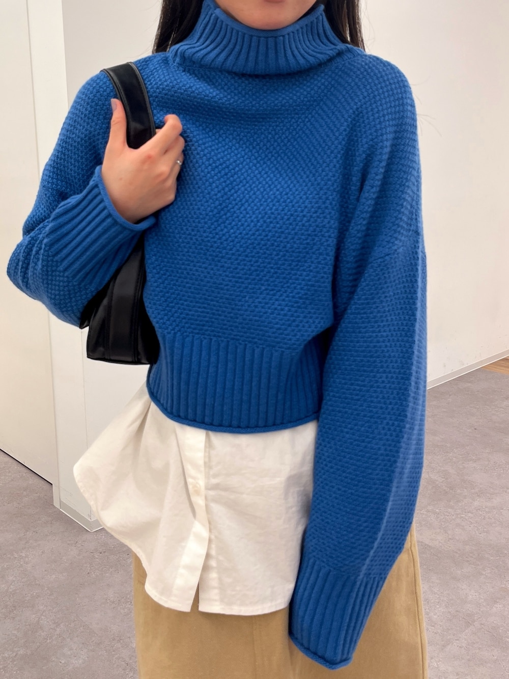 ブルー系のニット/セーター、ホワイト系のシャツ/ブラウスを着用したレディースの冬コーディネートの3枚目の写真