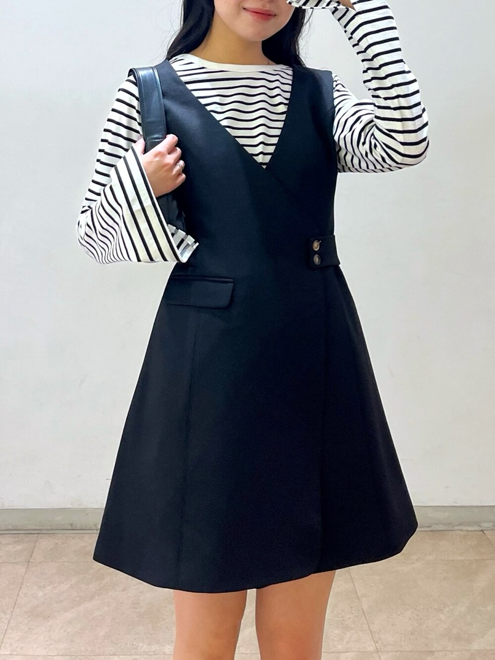 グリーン系のMA-1、ブラック系のワンピース、ブラック系のショルダーバッグを着用したレディースの冬コーディネートの4枚目の写真