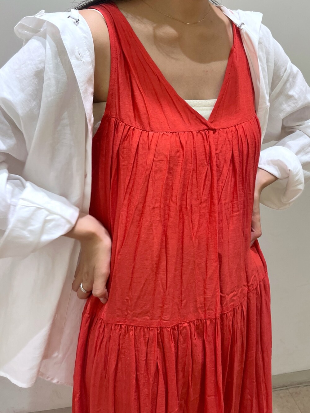 レッド系のワンピース、ブルー系のシャツ/ブラウス、ブラック系のパンプスを着用したレディースの夏コーディネートの3枚目の写真