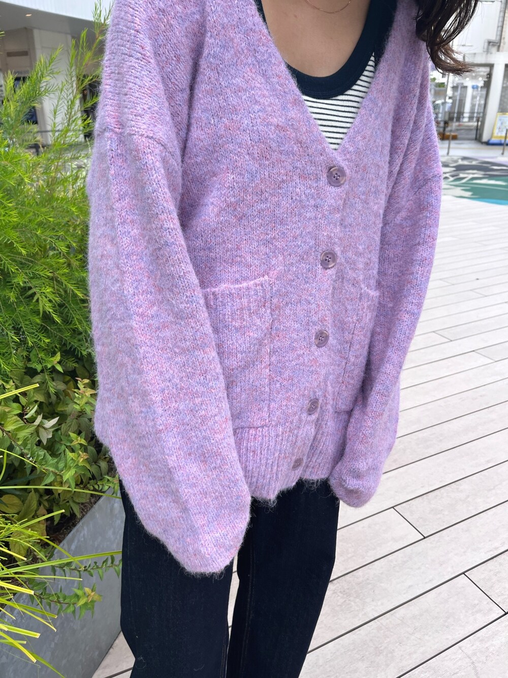 パープル系のカーディガン/ボレロ、ブルー系のデニムパンツ、ブラック系のスニーカーを着用したレディースの秋コーディネートの4枚目の写真