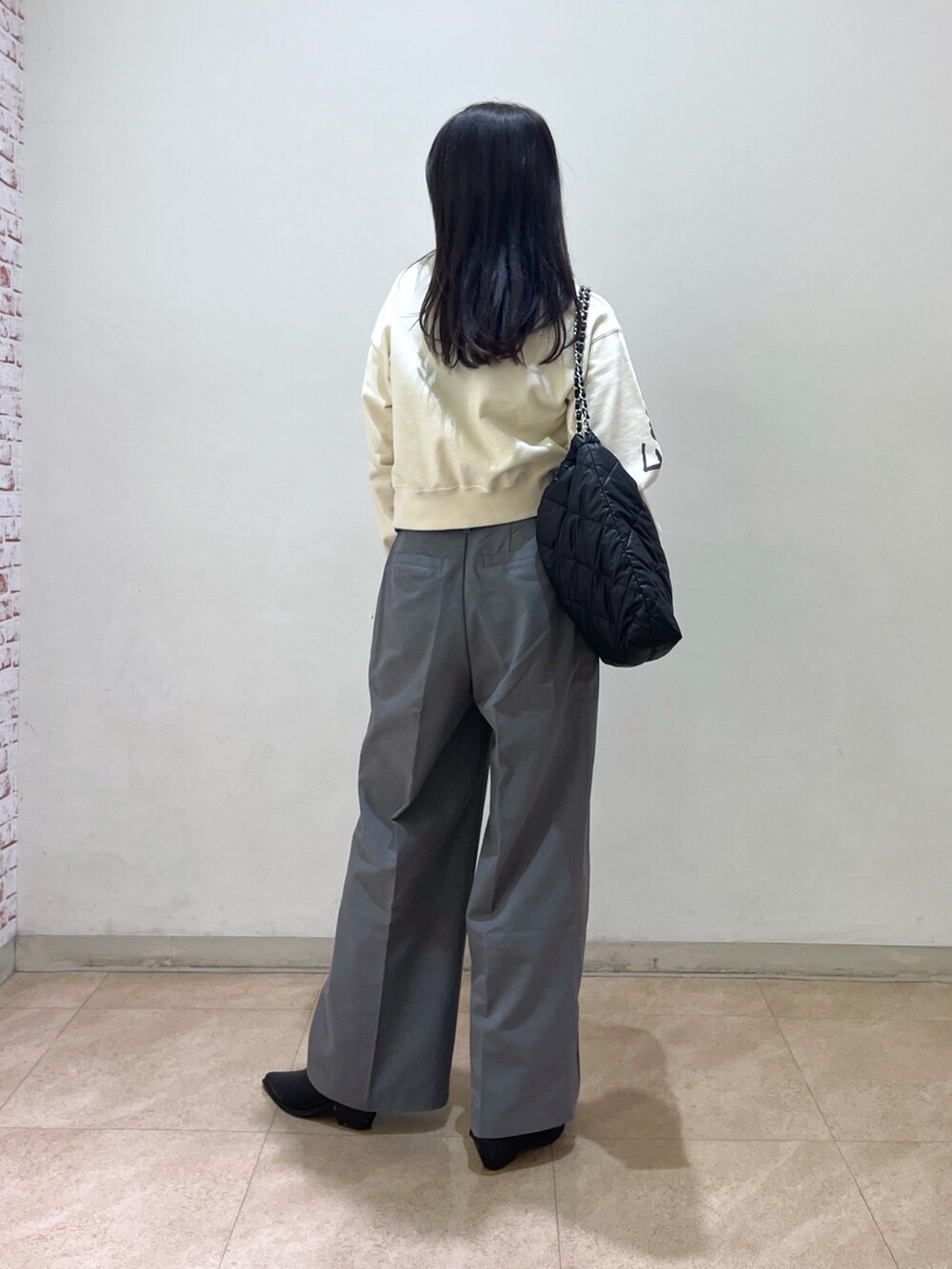 ブラック系のMA-1、ホワイト系のスウェット、グレー系のスラックスを着用したレディースの冬コーディネートの3枚目の写真