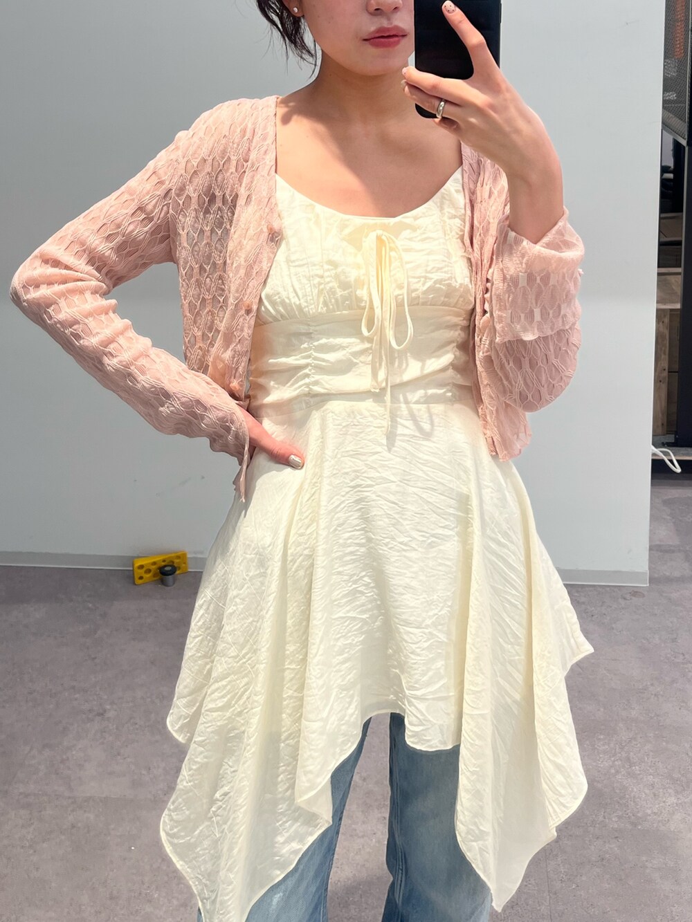 ホワイト系のワンピース、ピンク系のカーディガン/ボレロを着用したレディースの春コーディネートの2枚目の写真