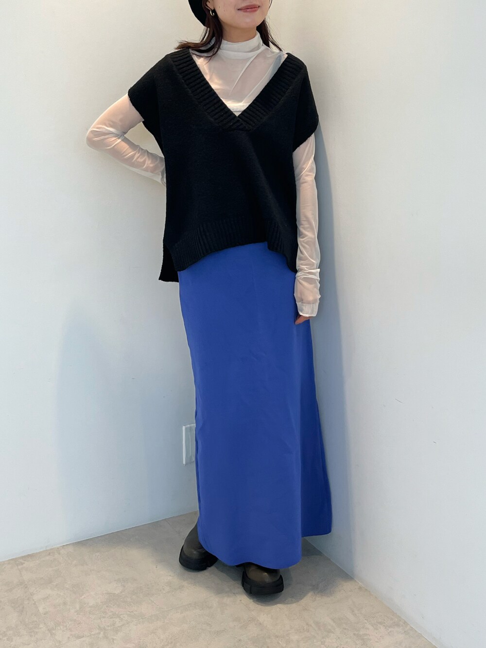 ホワイト系のTシャツ/カットソー、ブラック系のニット/セーター、ブルー系のスカートを着用したレディースの秋コーディネートの3枚目の写真