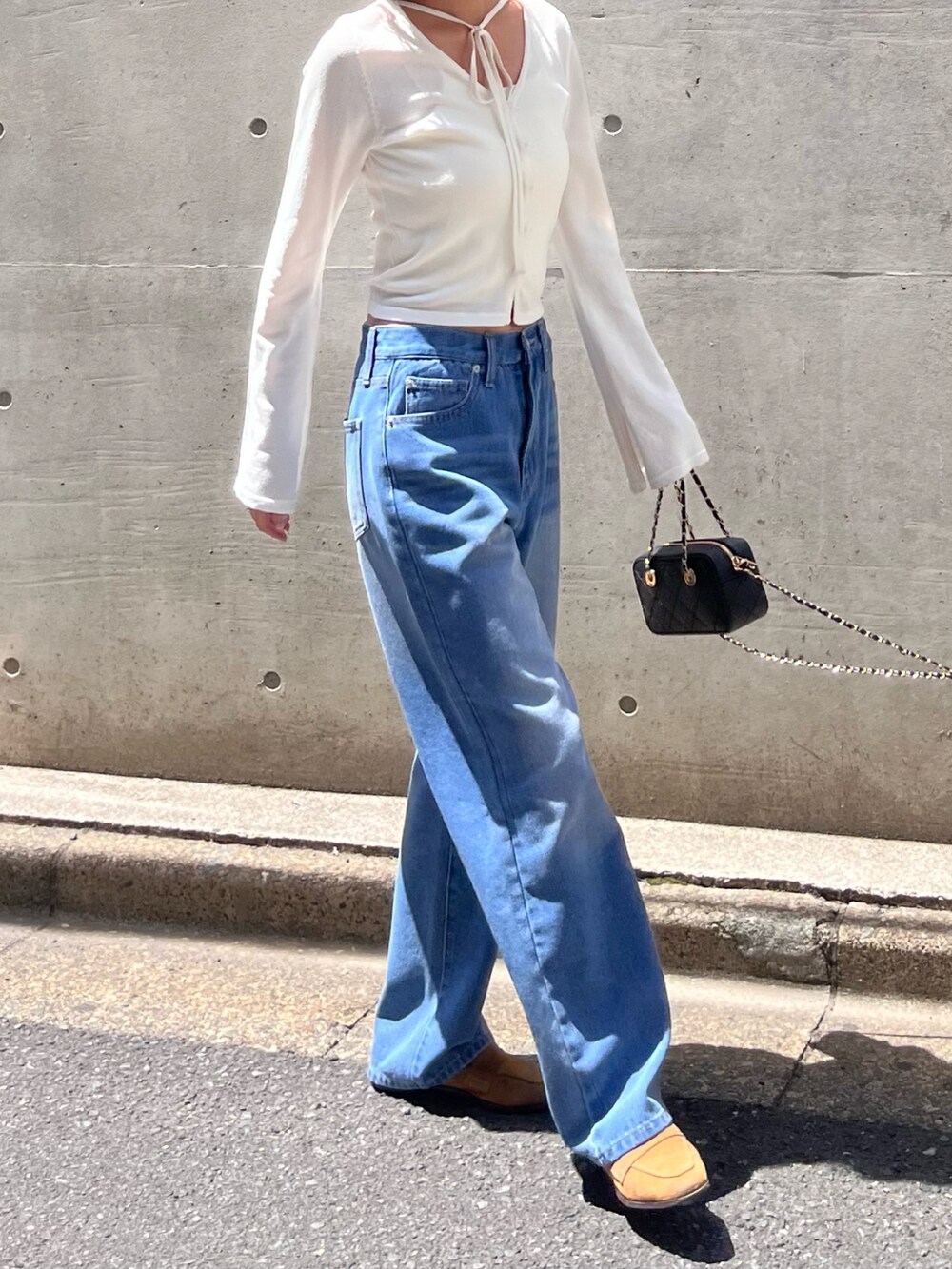 ホワイト系のニット/セーター、ブルー系のデニムパンツを着用したレディースの春コーディネートの2枚目の写真
