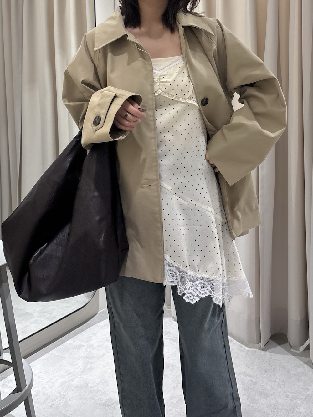 ホワイト系のワンピース、ブルー系のデニムパンツ、ブラウン系のトートバッグを着用したレディースの春コーディネートの2枚目の写真