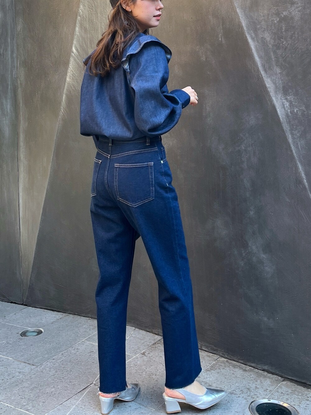 ブルー系のデニムパンツ、ブラック系のショルダーバッグを着用したレディースの春コーディネートの2枚目の写真