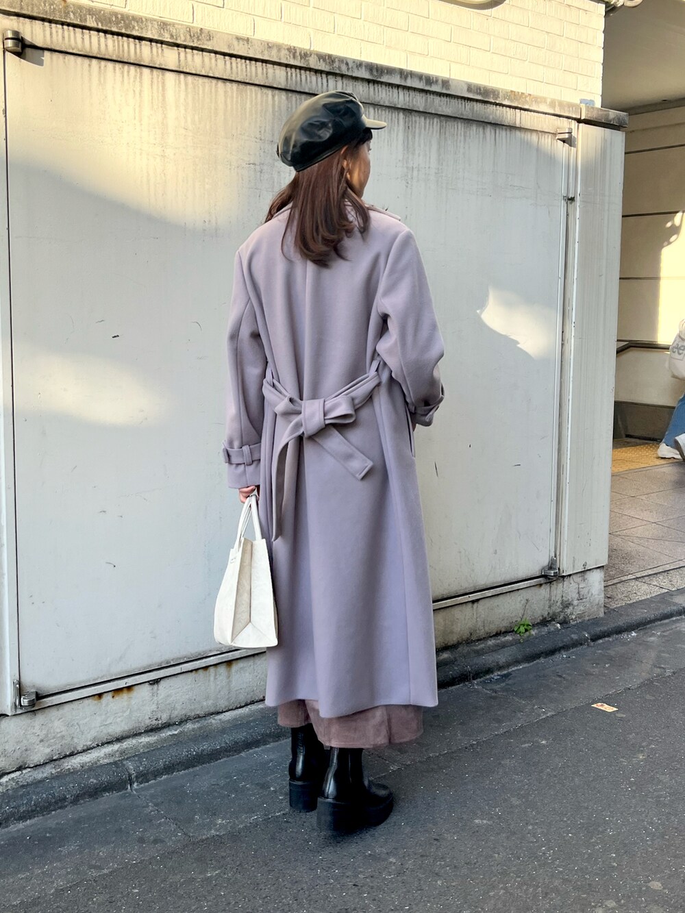 ブラック系のニット/セーター、パープル系のチェスターコート、ブラウン系のスカートを着用したレディースの秋コーディネートの4枚目の写真