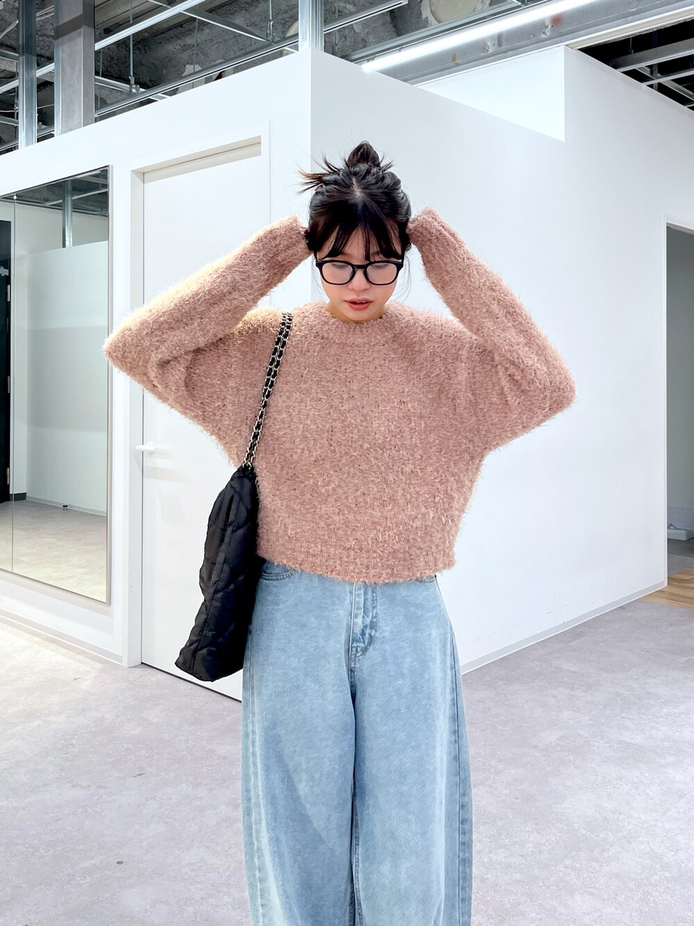 ピンク系のニット/セーター、ブルー系のデニムパンツ、ホワイト系のスニーカーを着用したレディースの冬コーディネートの3枚目の写真