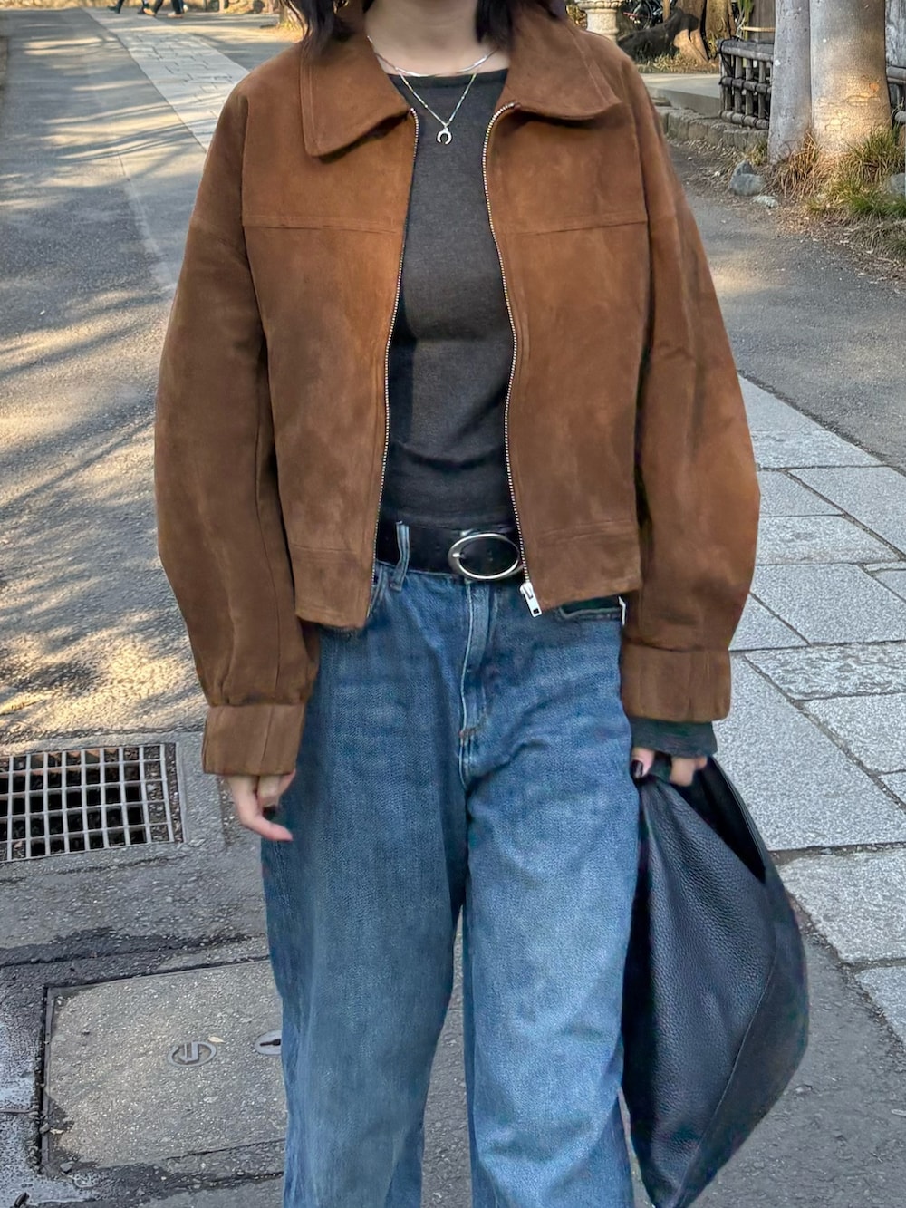 ブラウン系のブルゾンを着用したレディースの冬コーディネートの3枚目の写真