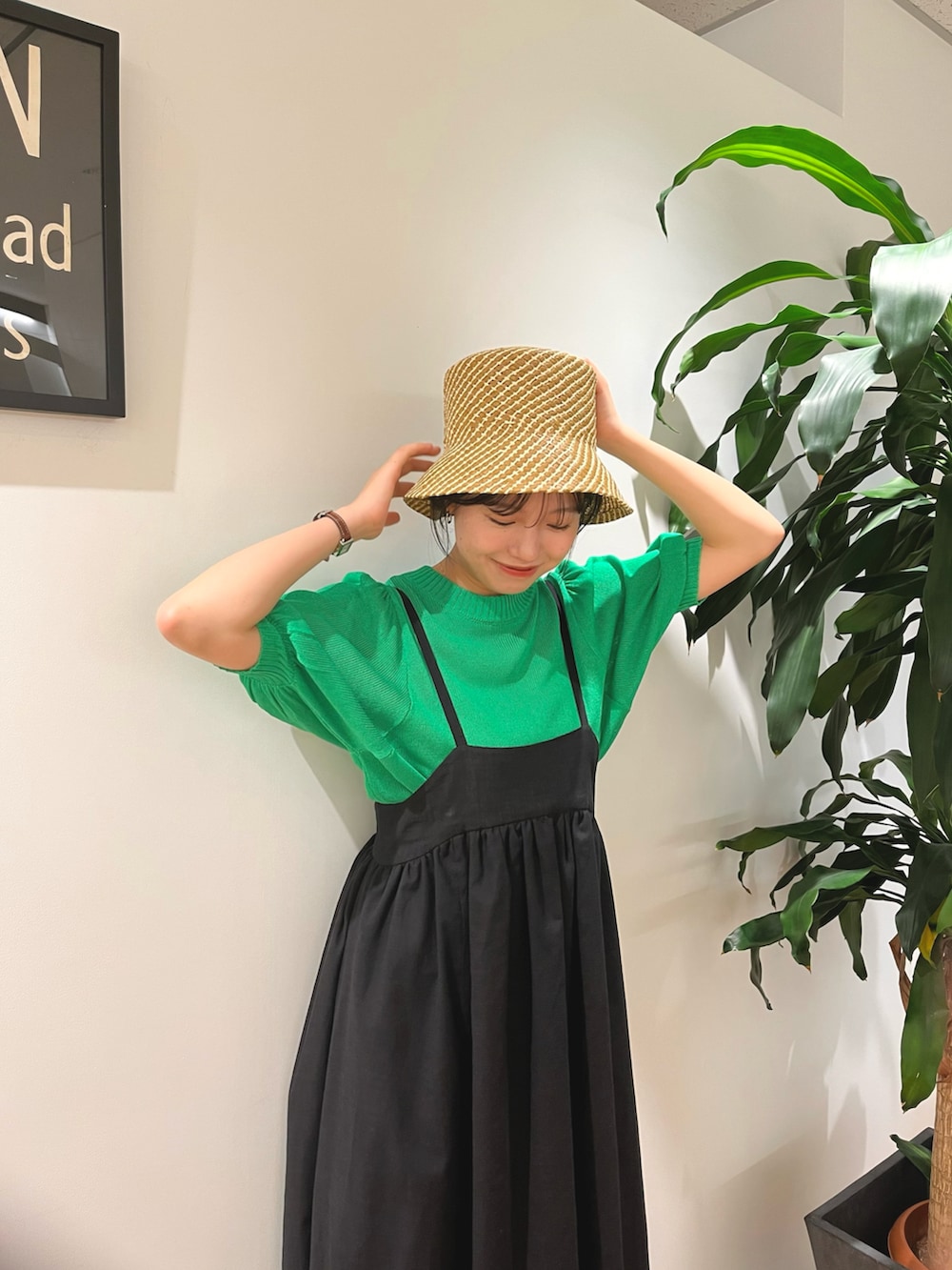 グリーン系のニット/セーター、ブラック系のワンピース、ホワイト系のサンダルを着用したレディースの夏コーディネートの4枚目の写真