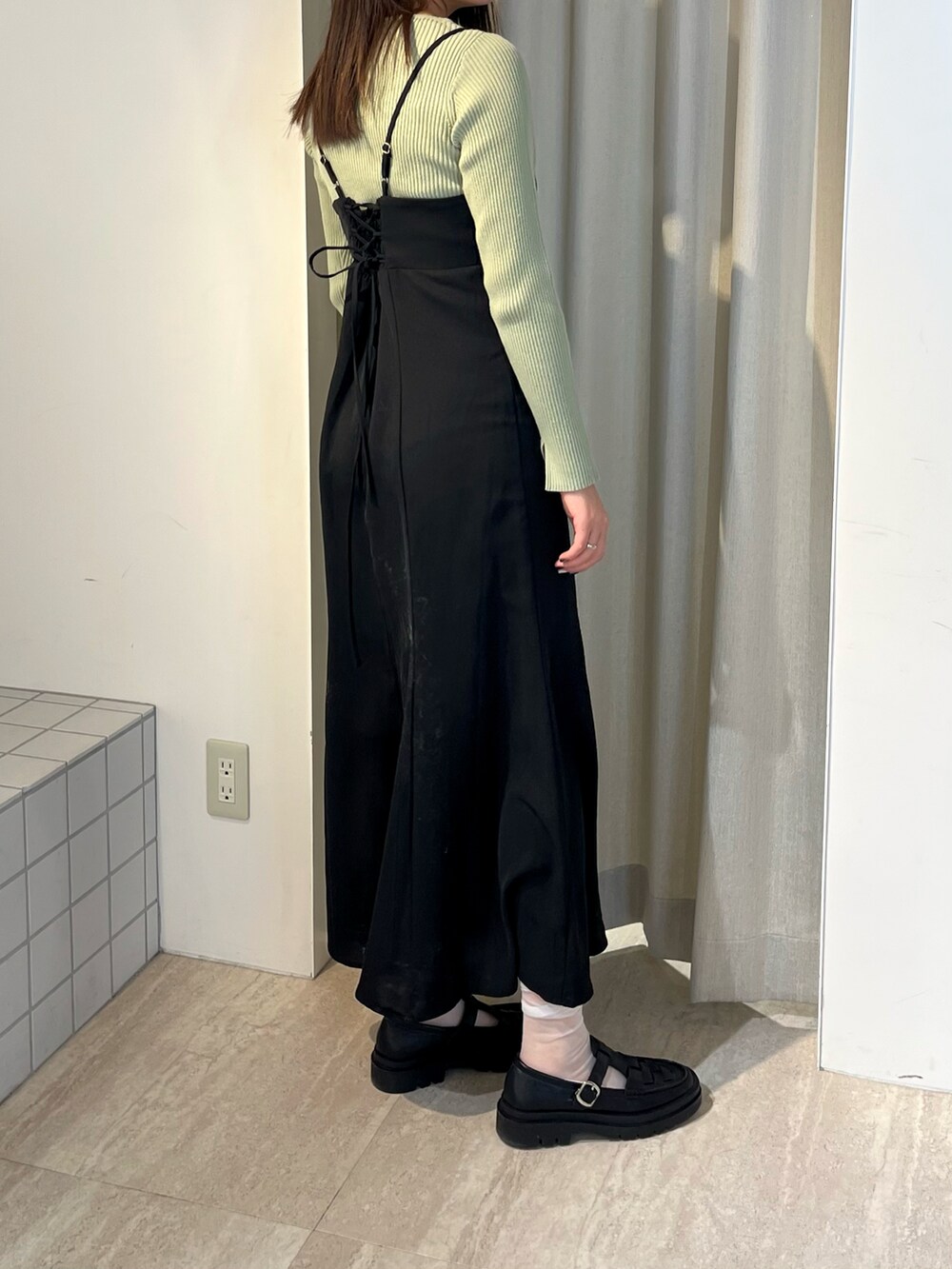 グリーン系のニット/セーター、グリーン系のワンピース、ブラック系のローファーを着用したレディースの冬コーディネートの4枚目の写真