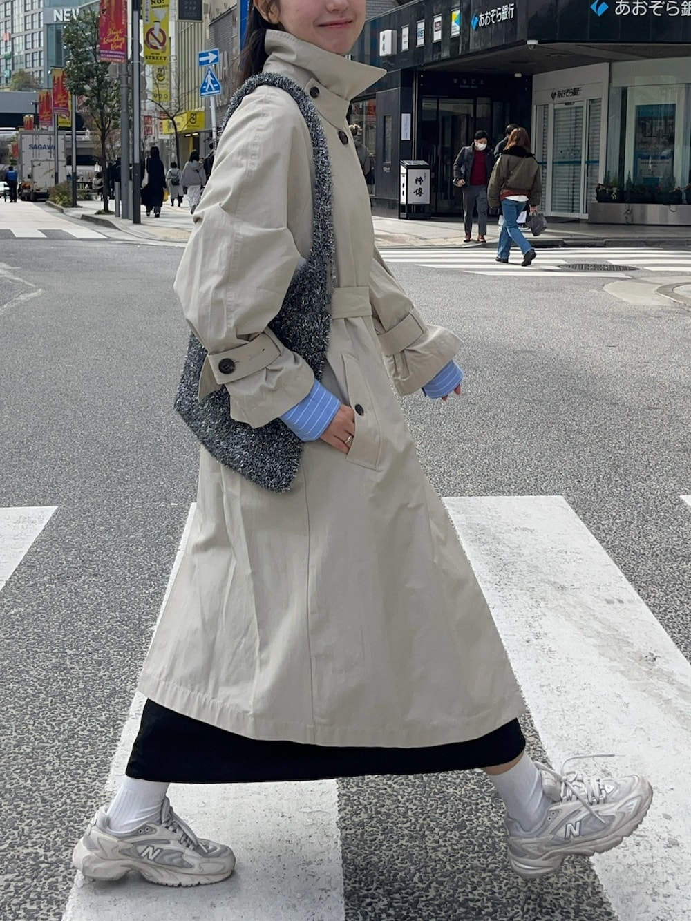 ベージュ系のトレンチコート、ホワイト系のスニーカーを着用したレディースの冬コーディネートの2枚目の写真
