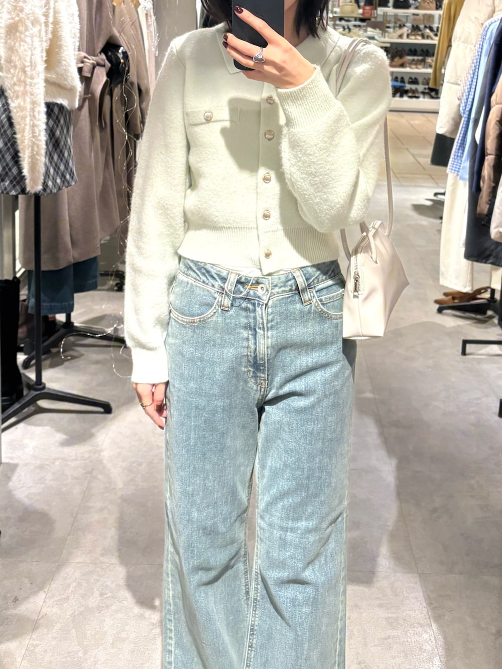 グリーン系のニット/セーター、ホワイト系のデニムパンツを着用したレディースの冬コーディネートの2枚目の写真