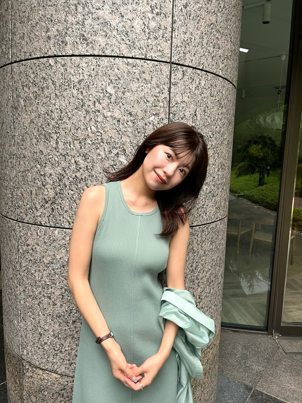 グリーン系のワンピースを着用したレディースの夏コーディネートの2枚目の写真