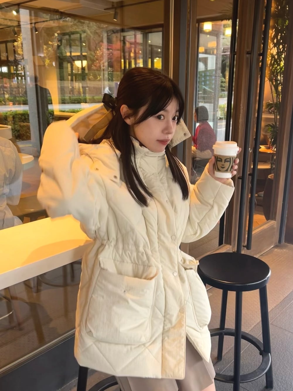 ホワイト系のダウンジャケット/コート、ブラック系のスカートを着用したレディースの冬コーディネートの3枚目の写真