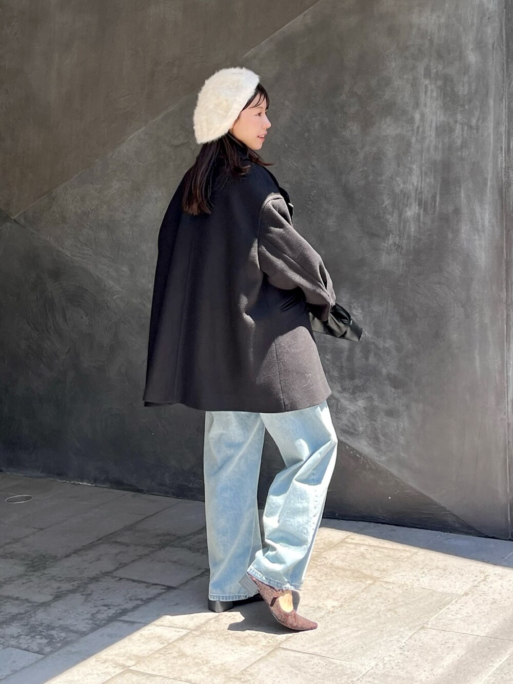 ブラック系のピーコート、ブルー系のデニムパンツを着用したレディースの夏コーディネートの2枚目の写真