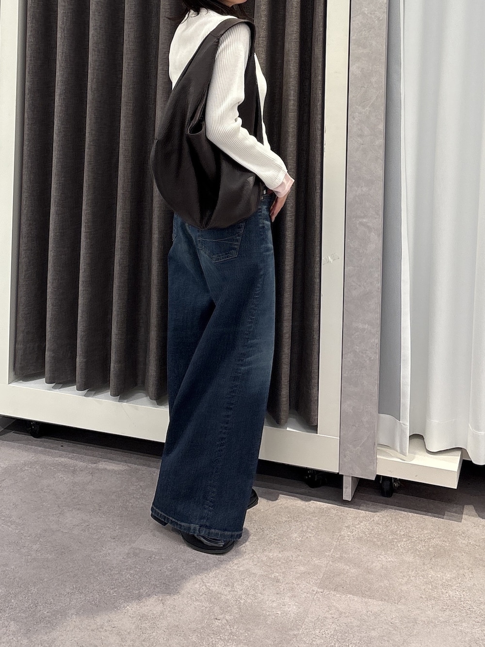 グレー系のニット/セーター、ブルー系のデニムパンツを着用したレディースの冬コーディネートの2枚目の写真