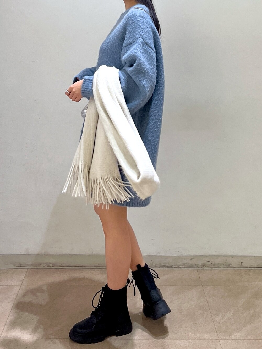 ブルー系のワンピース、シルバー系のハンドバッグ、ブラック系のブーツを着用したレディースの冬コーディネートの3枚目の写真