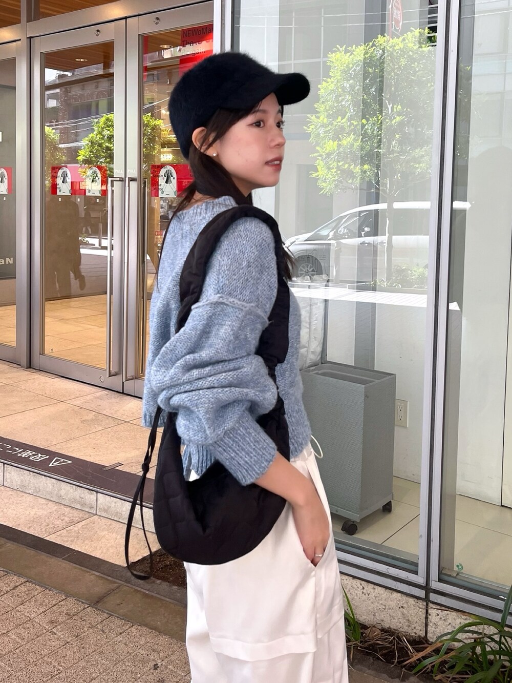 ブラック系のブルゾン、ブルー系のニット/セーター、ホワイト系のカーゴパンツを着用したレディースの冬コーディネートの5枚目の写真