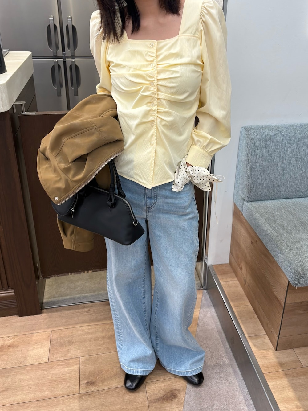 イエロー系のシャツ/ブラウス、ベージュ系のブルゾン、ブルー系のデニムパンツを着用したレディースの春コーディネートの2枚目の写真