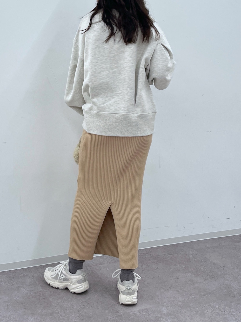 ホワイト系のスウェット、ゴールド系のスカート、ピンク系のショルダーバッグを着用したレディースの冬コーディネートの3枚目の写真