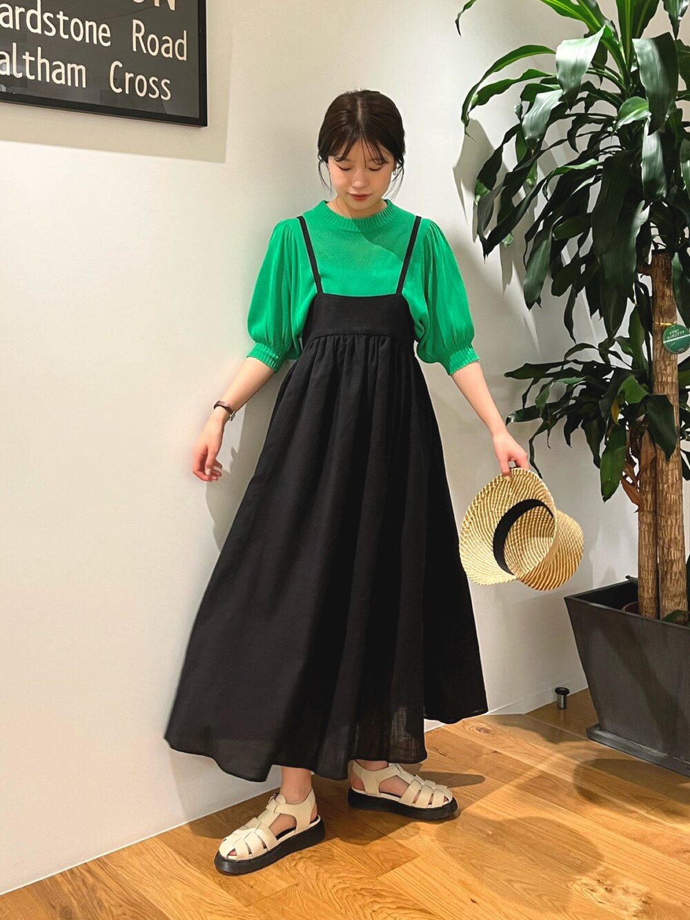 グリーン系のニット/セーター、ブラック系のワンピース、ホワイト系のサンダルを着用したレディースの夏コーディネートの2枚目の写真