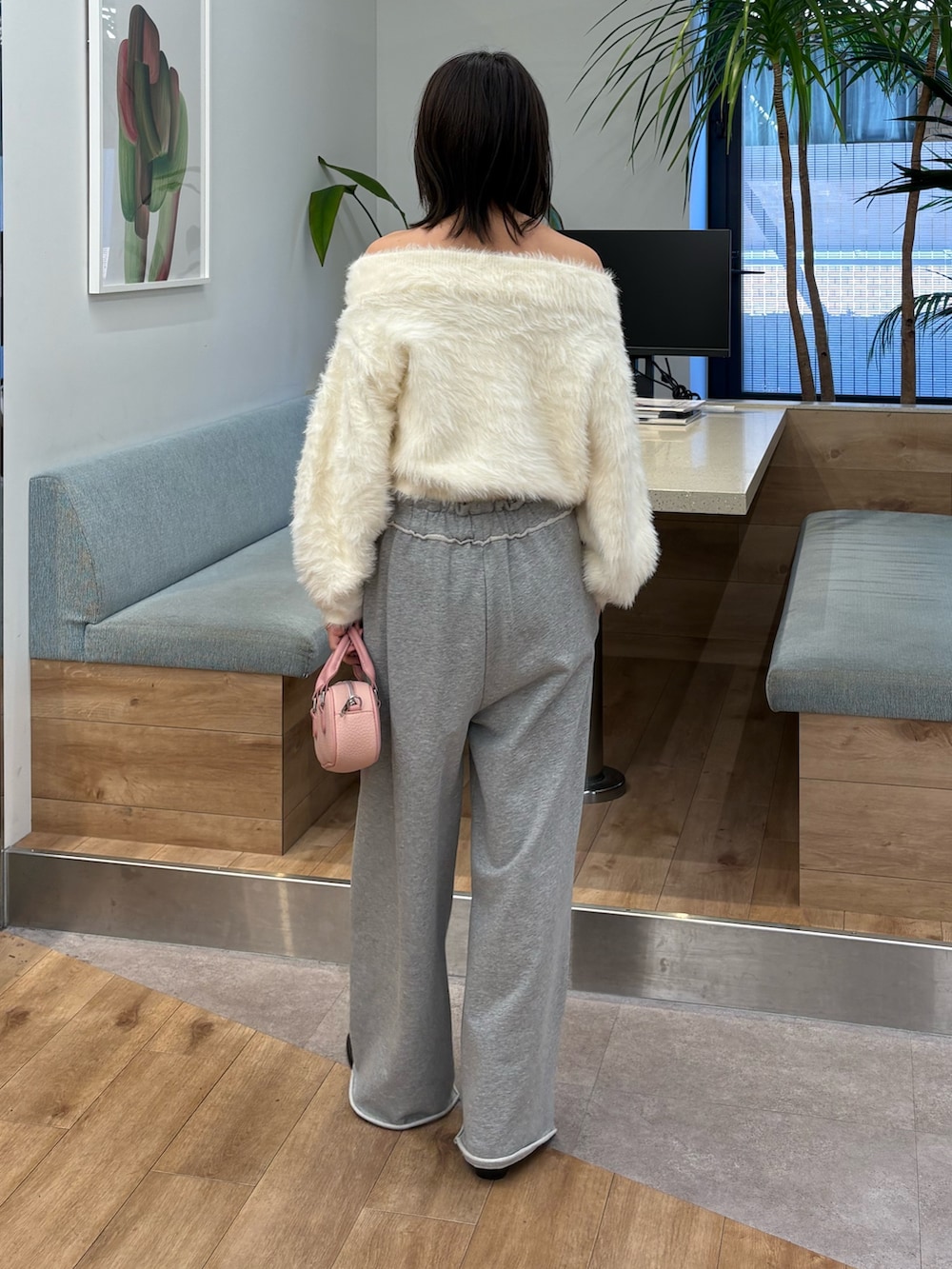 ホワイト系のニット/セーター、グレー系のその他パンツを着用したレディースの冬コーディネートの2枚目の写真