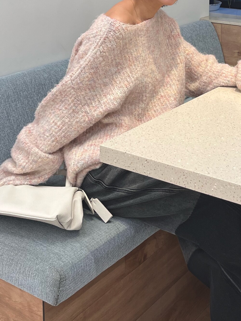 ピンク系のニット/セーター、ブラック系のデニムパンツ、ホワイト系のマフラーを着用したレディースの冬コーディネートの2枚目の写真