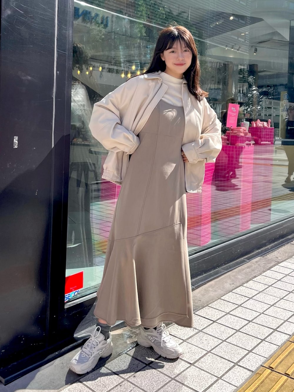 ブラウン系のワンピース、ホワイト系のTシャツ/カットソー、ホワイト系のライダースジャケットを着用したレディースの秋コーディネートの2枚目の写真