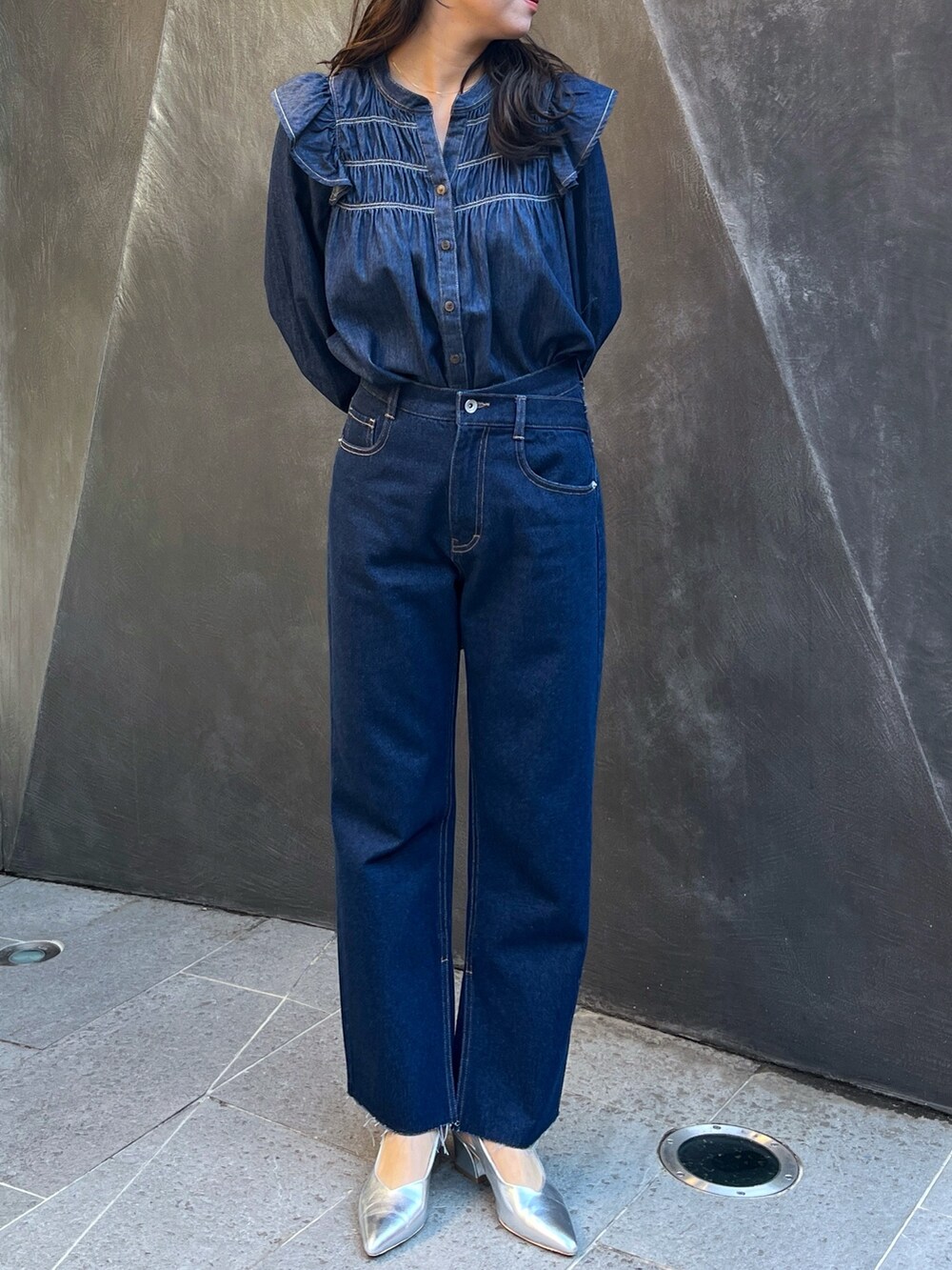 ブルー系のデニムパンツ、ブラック系のショルダーバッグを着用したレディースの春コーディネートの3枚目の写真