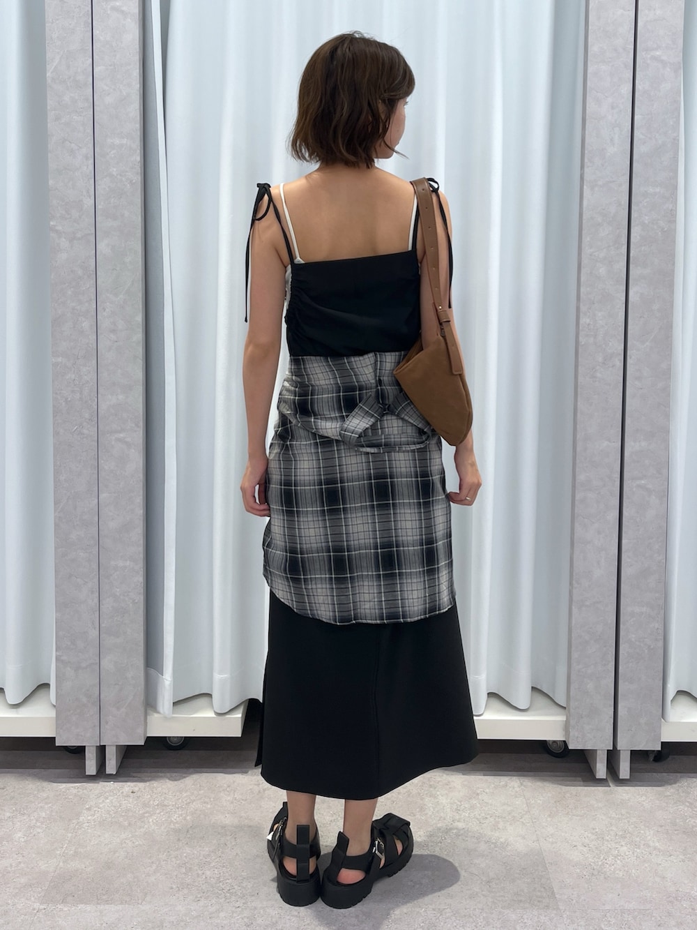 ブラウン系のワンピース、ブラック系のシャツ/ブラウス、ブラウン系のサンダルを着用したレディースの夏コーディネートの2枚目の写真