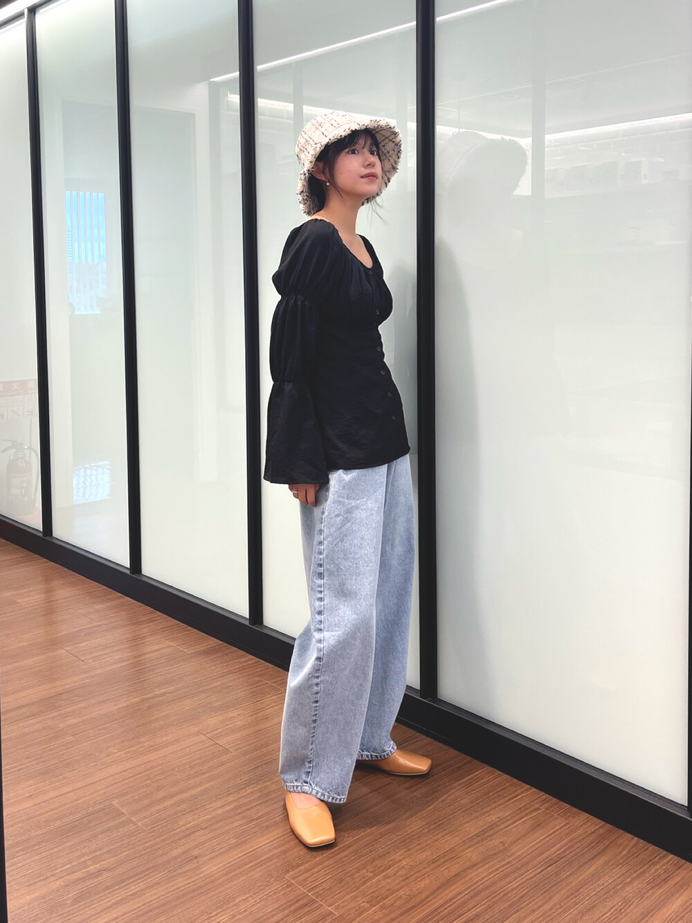 ブラック系のシャツ/ブラウス、ブルー系のデニムパンツ、ホワイト系のハットを着用したレディースの夏コーディネートの2枚目の写真