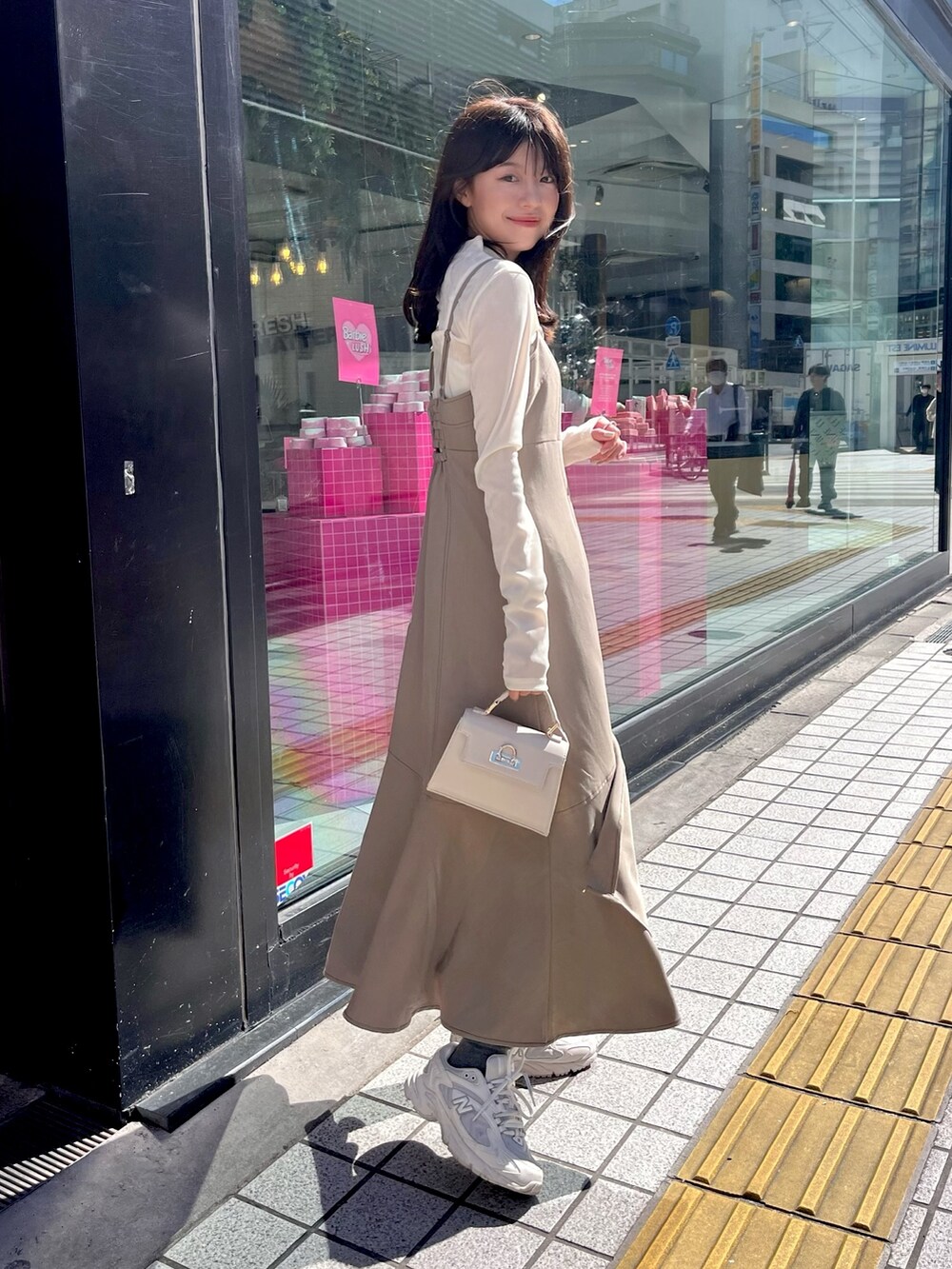 ブラウン系のワンピース、ホワイト系のTシャツ/カットソー、ホワイト系のライダースジャケットを着用したレディースの秋コーディネートの3枚目の写真