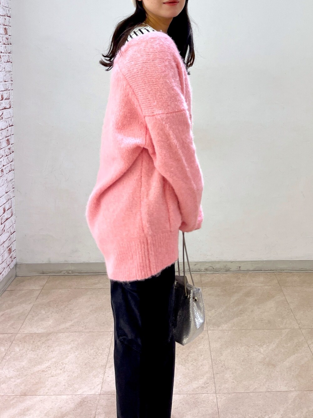 ピンク系のカーディガン/ボレロ、ブラック系のTシャツ/カットソー、ブラック系のデニムパンツを着用したレディースの冬コーディネートの3枚目の写真