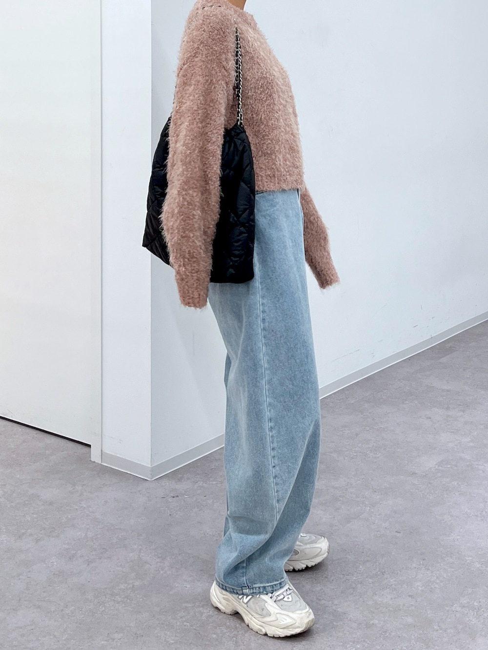 ピンク系のニット/セーター、ブルー系のデニムパンツ、ホワイト系のスニーカーを着用したレディースの冬コーディネートの2枚目の写真