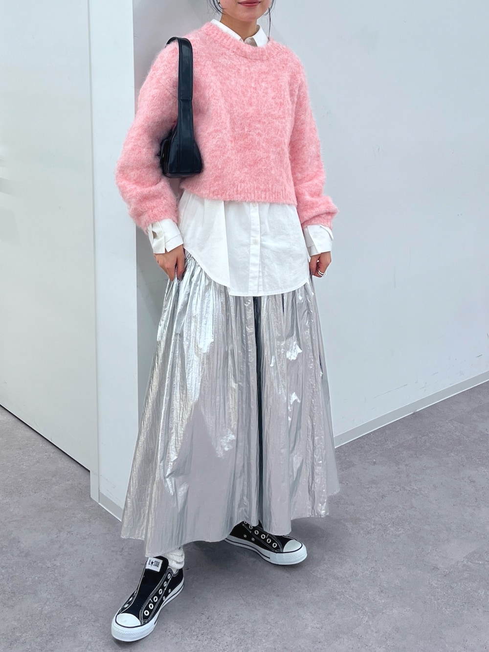 ピンク系のニット/セーター、ホワイト系のシャツ/ブラウス、シルバー系のスカートを着用したレディースの冬コーディネートの2枚目の写真