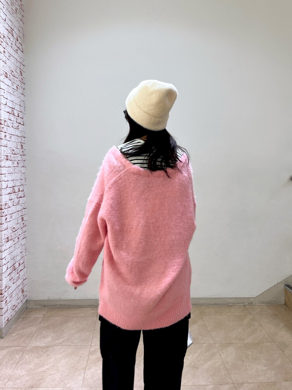 ピンク系のカーディガン/ボレロ、ブラック系のTシャツ/カットソー、ブラック系のデニムパンツを着用したレディースの冬コーディネートの4枚目の写真